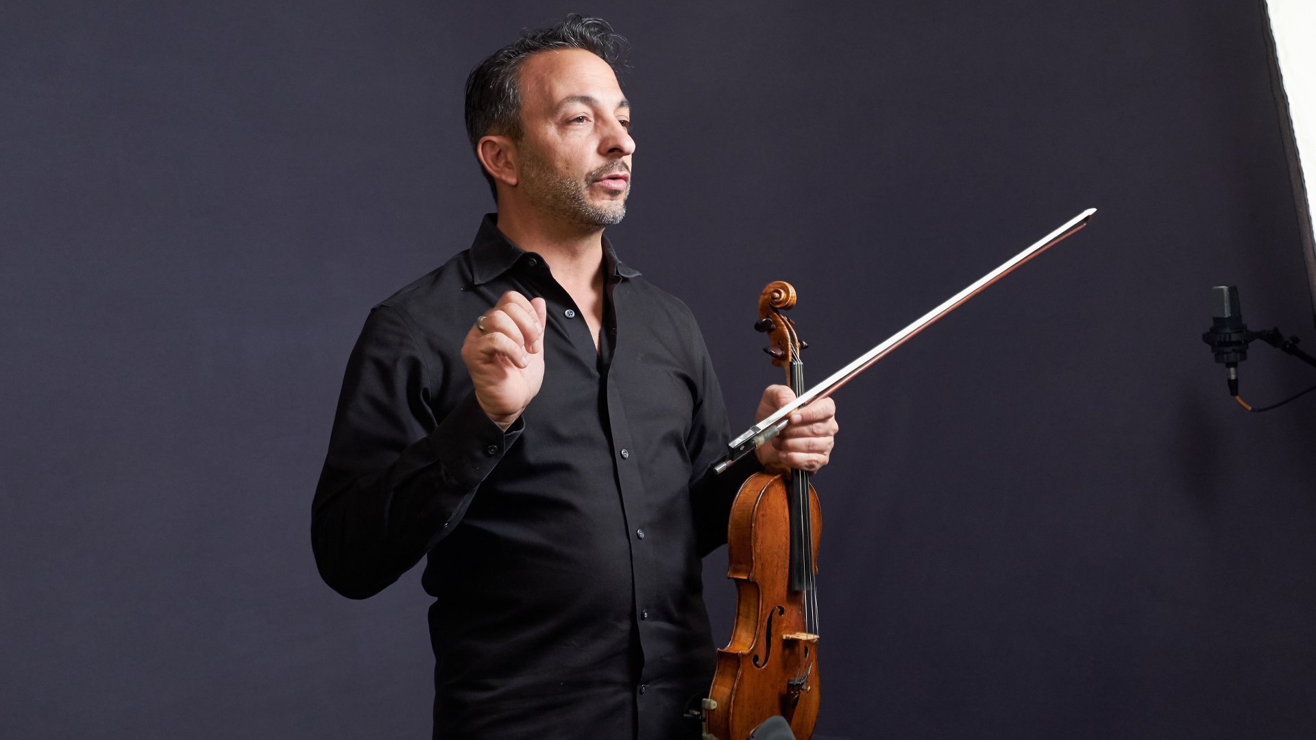 Richard Amoroso teaching with his violin and bow